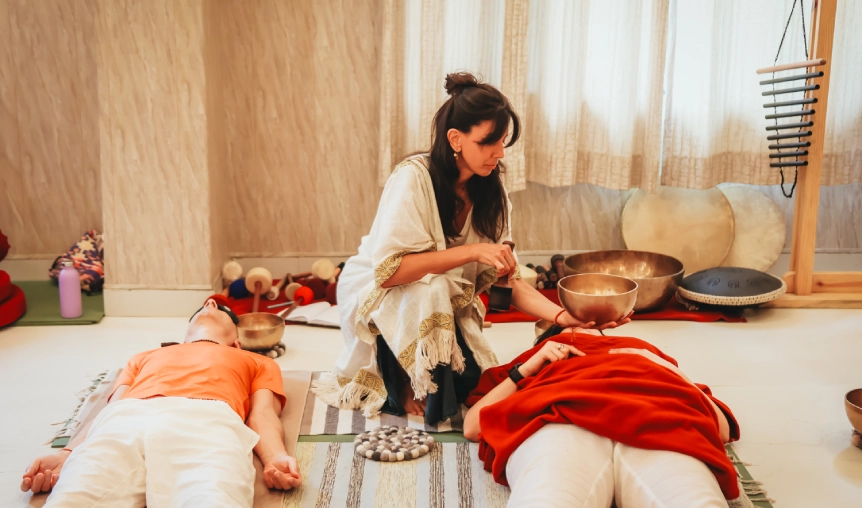 Students attending singing bowl theory class with bowls aligned during sound healing course in Rishikesh